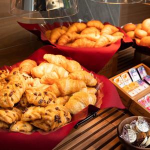 a bunch of breads and pastries on a table at Super Hotel Nagano Iida Inter in Iida