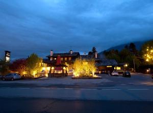 a building with lights in a parking lot at night at Hotel Village in Aosta