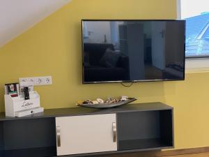TV de pantalla plana en la pared de la sala de estar. en Apartment Köln Ensen, en Colonia