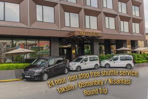 trzy samochody zaparkowane na parkingu przed budynkiem w obiekcie Naz City Hotel Taksim - Special Category w Stambule