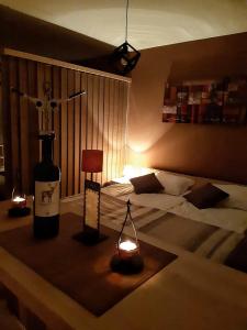 F307 Studio Aspen Golf Resort Bansko في بانسكو: غرفة مع سرير وزجاجة من النبيذ وأضواء