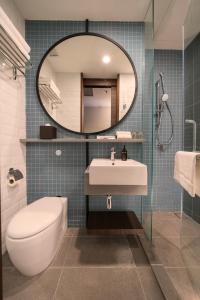 a bathroom with a toilet and a sink and a mirror at Travelodge Chinatown Kuala Lumpur in Kuala Lumpur