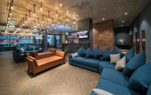 a waiting room with blue couches and a tv at Travelodge Chinatown Kuala Lumpur in Kuala Lumpur