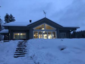 a house with snow in front of it at Villa Avanto in Suomenniemi