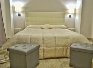 a bedroom with a large bed with two ottomans at B&B Lungomare in Catania