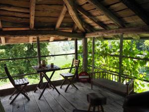 a porch with a table and chairs in a cabin at Le Chatel en Beaujolais in Valsonne