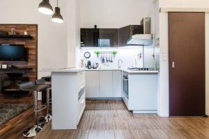 ブダペストにあるOrsi's sweet & lovely homeの白い家電製品とデスク付きのキッチンが備わる客室です。