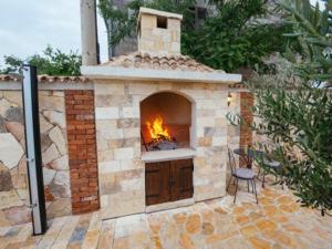 um forno de tijolos com um fogo dentro dele em Holiday home Iva with pool em Sukošan