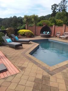 a swimming pool with two chairs and a fire pit at Chartré Manor B&B in Thames