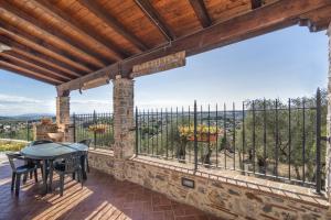 an outdoor patio with a table and chairs and a large window at Colle La Fosca - Casa panoramica in Massarosa