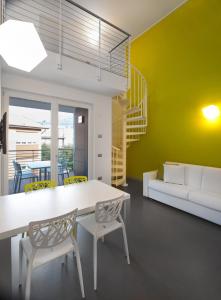 - un salon avec une table et des chaises blanches dans l'établissement Gardabike Residence, à Nago-Torbole