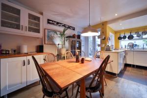 a kitchen and dining room with a wooden table and chairs at The Green House in Liverpool