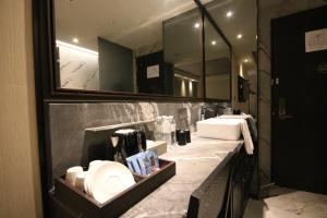 a bathroom with two sinks and two mirrors at Hotel Midtown Richardson - Kaohsiung Bo'ai in Kaohsiung +51 photos