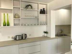 a white kitchen with white cabinets and a sink at Sea View Holiday Apartment in Larnaca
