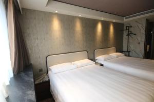 a hotel room with two beds and two lamps at Hotel Midtown Richardson - Kaohsiung Bo'ai in Kaohsiung