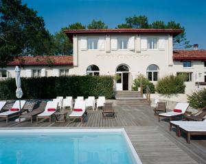 uma villa com piscina em frente a uma casa em Hotel La Maison de la Prade em Messanges