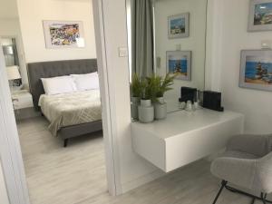 a bedroom with a bed and a table and a mirror at Sea View Holiday Apartment in Larnaca