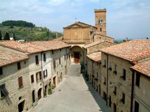 Une allée dans une vieille ville avec une tour de l'horloge dans l'établissement Casa Ricciardi, à Chianni