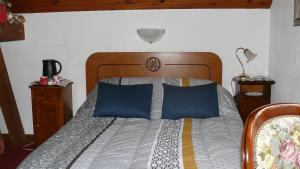 1 dormitorio con 1 cama grande con almohadas azules en chambre chez sylvie, en Haux