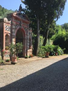 un arco en medio de un jardín con plantas en Villa Ilaria, en Capannori