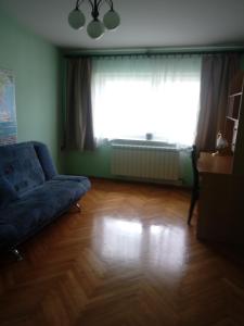 uma sala de estar com um sofá azul e uma grande janela em villa em Nowa Ruda