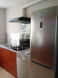 uma cozinha com um frigorífico de aço inoxidável e um fogão em villa em Nowa Ruda