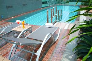a table and chairs next to a swimming pool at Amora NeoLuxe Suites Hotel in Bangkok