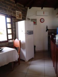 a kitchen with a white refrigerator in a room at Bangalô Menotti in Prado