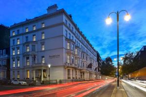 un gran edificio blanco en una calle de la ciudad por la noche en Fraser Suites Queens Gate, en Londres