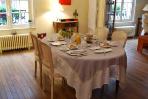 a dining room table with a white table cloth on it at Le Clos des Roys in Reims