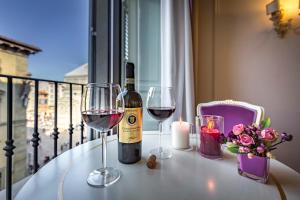 una bottiglia di vino e due bicchieri su un tavolo di B&B La Terrazza Sul Duomo a Firenze