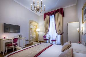 a bedroom with a bed and a desk and a television at B&B La Terrazza Sul Duomo in Florence