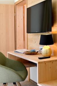 Zimmer mit einem Schreibtisch, einem TV und einem Stuhl in der Unterkunft Gasthof Pension Seidl in Arbesbach