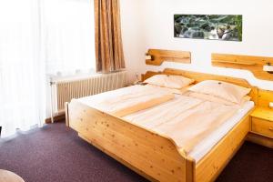 sypialnia z dużym drewnianym łóżkiem w pokoju w obiekcie Gasthof Pension Seidl w mieście Arbesbach