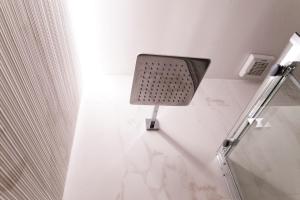 une salle de bains blanche avec une lumière sur le mur. dans l'établissement Casa Veniero, à Rome