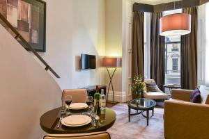 a living room with a table and a couch at Fraser Suites Queens Gate in London