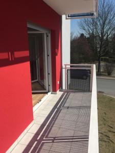 a red building with a red wall and a door at Mara in Bad Nauheim