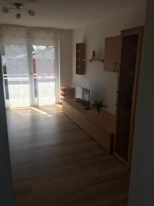 a living room with a large door and a room with wooden floors at Mara in Bad Nauheim