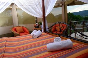een slaapkamer met een bed met handdoeken erop bij ELANGATA OLERAI LUXURY TENTED CAMP in Narok