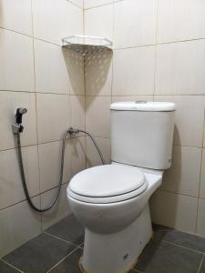 a bathroom with a toilet with a shower at Motel Aurora Damai in Pantai Cenang