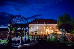 a house with a gazebo in front of it at night at Castel Haller in Ogra