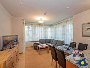ein Wohnzimmer mit Couch und Fernseher in der Unterkunft Villen am Goethepark, Villa Christiane, Whg. 04 - Lena in Heringsdorf