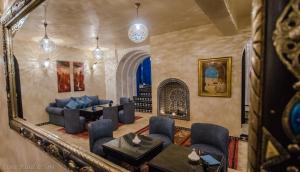 a living room with blue furniture and a mirror at Lina Ryad & Spa in Chefchaouene