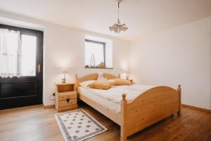 a bedroom with a wooden bed and a window at Baita Meidlnhof in Fierozzo