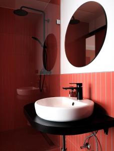 a bathroom with a white sink and a mirror at The Dot | 24/7 Checkin in Munich