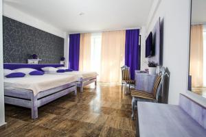 a bedroom with two beds with blue pillows at Lavender Villa in Mamaia Sat/Năvodari +19 photos