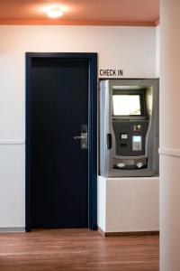 un cajero automático con una señal de registro de entrada en The Dot | 24/7 Checkin en Múnich