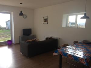 a living room with a couch and a table at GÎTE Les Buis in Bussière-Portevine