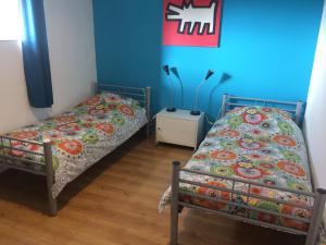 Duas camas num quarto com paredes azuis em GÎTE Les Buis em Bussière-Portevine