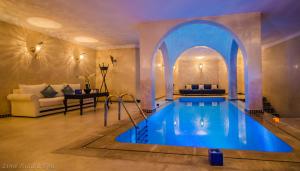 a swimming pool in a room with a living room at Lina Ryad & Spa in Chefchaouene